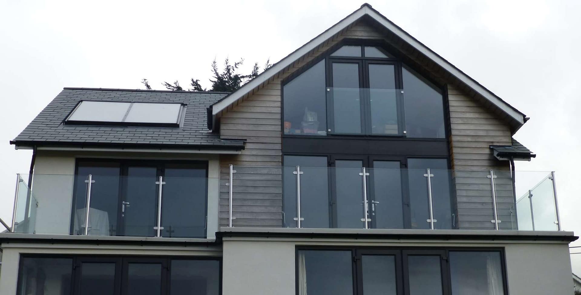 Modern glass balcony balustrades on a contemporary coastal home with panoramic views
