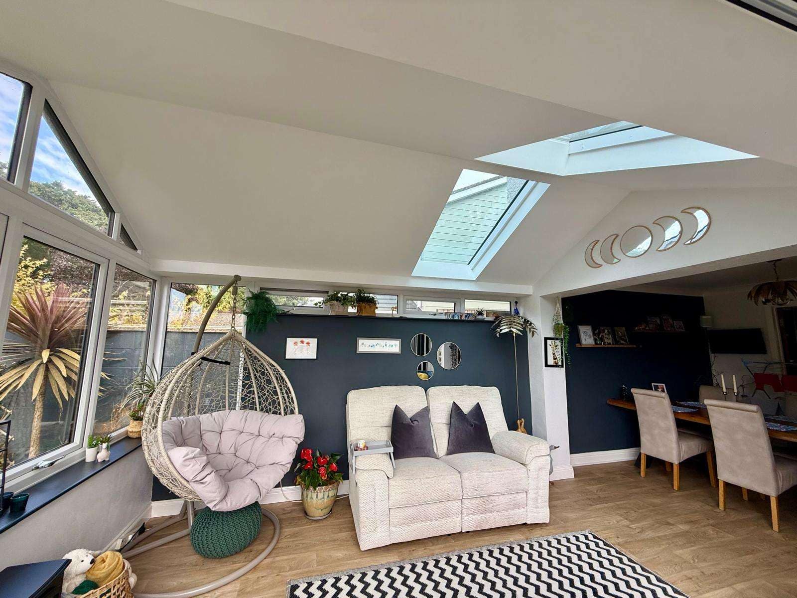 Bright garden room interior with two rooflights, large windows and a seating area.