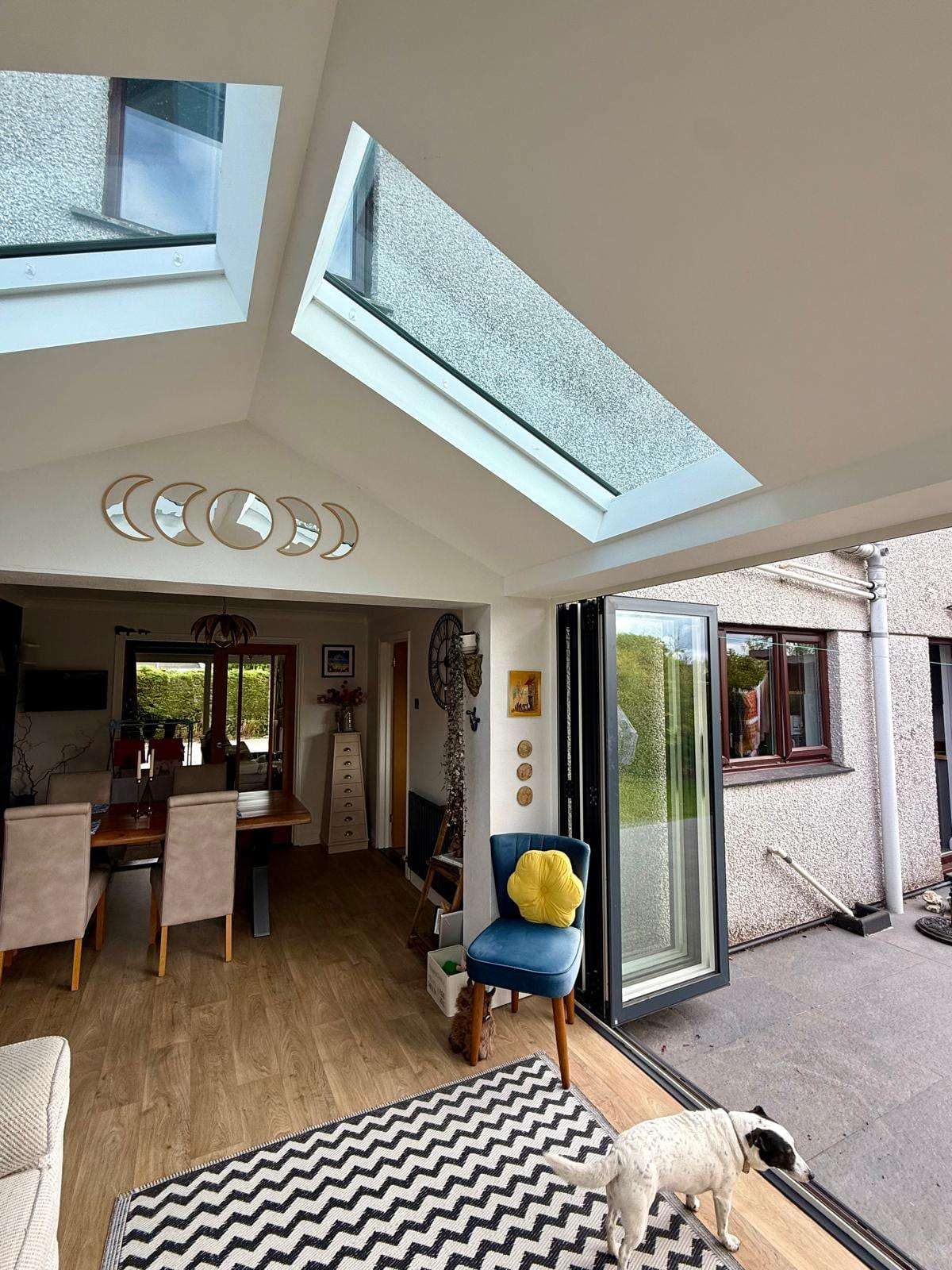 Garden room interior showing glazed roof sections and bifold doors opened onto the patio.